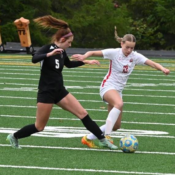 A LCC soccer player stealing the ball from the opposing team.