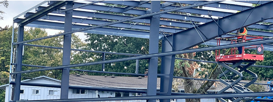 workers in their machine lifts working on building framework