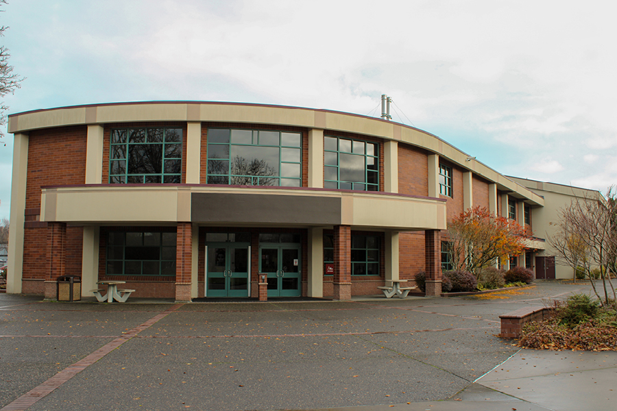 Student Center LCC Student Center, a modern brick building with large windows, a curved roof, and autumn foliage in the surrounding landscape. Cloudy sky above.