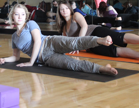 Students performing leg raises in a yoga class
