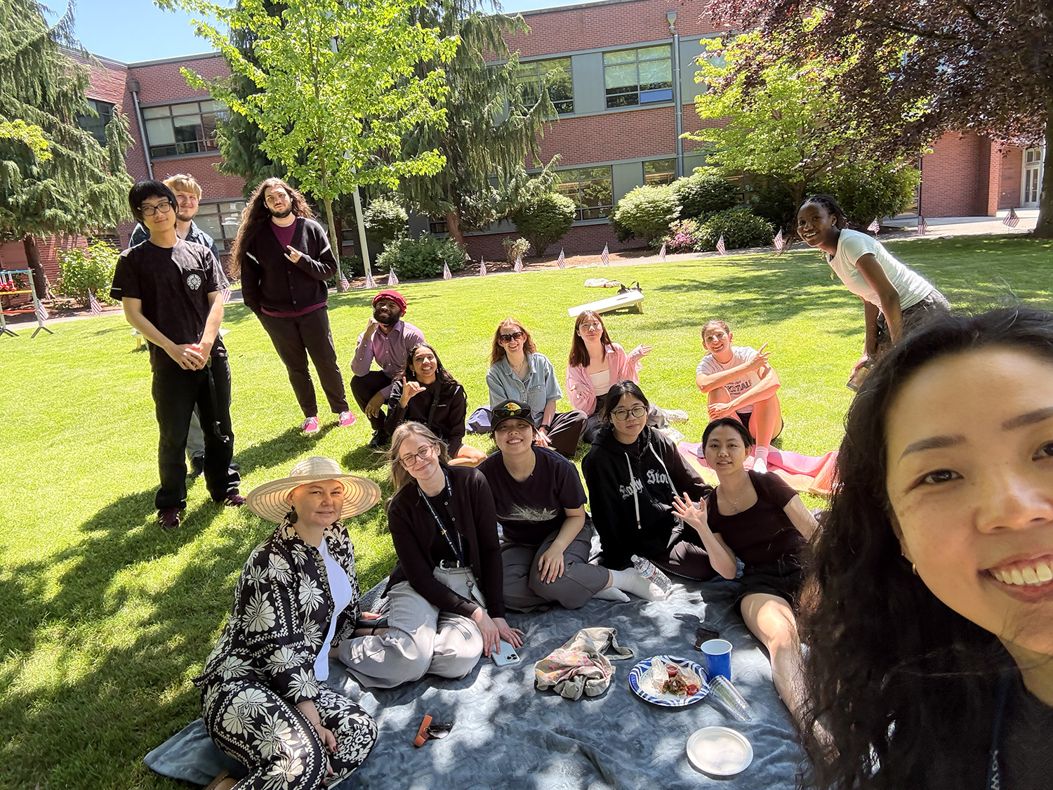 Selfie By Keiko Selfie of 15 people sitting in the shade of a tree smiling