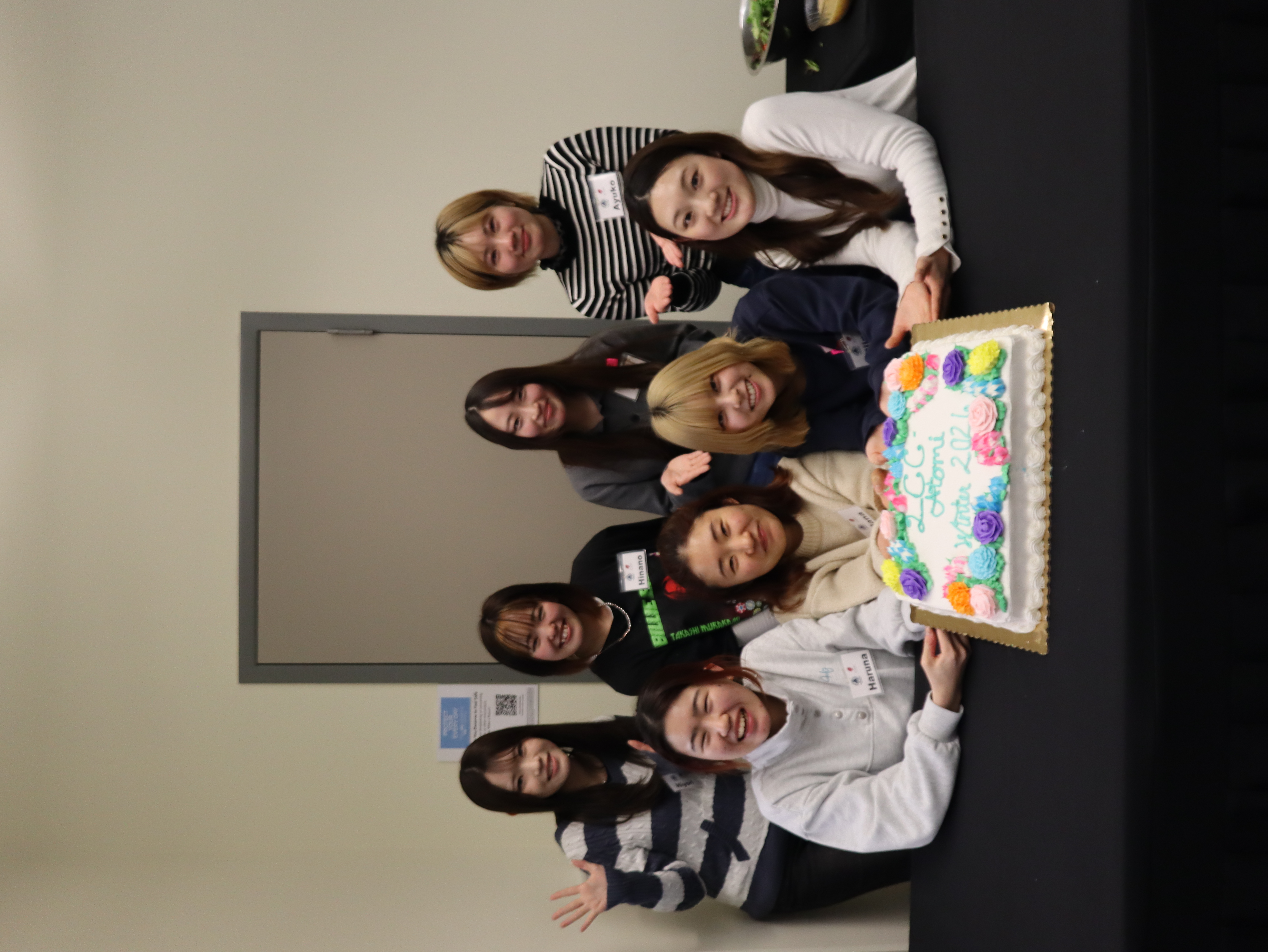 farwell gathering with 8 female international students showing off a farwell cake