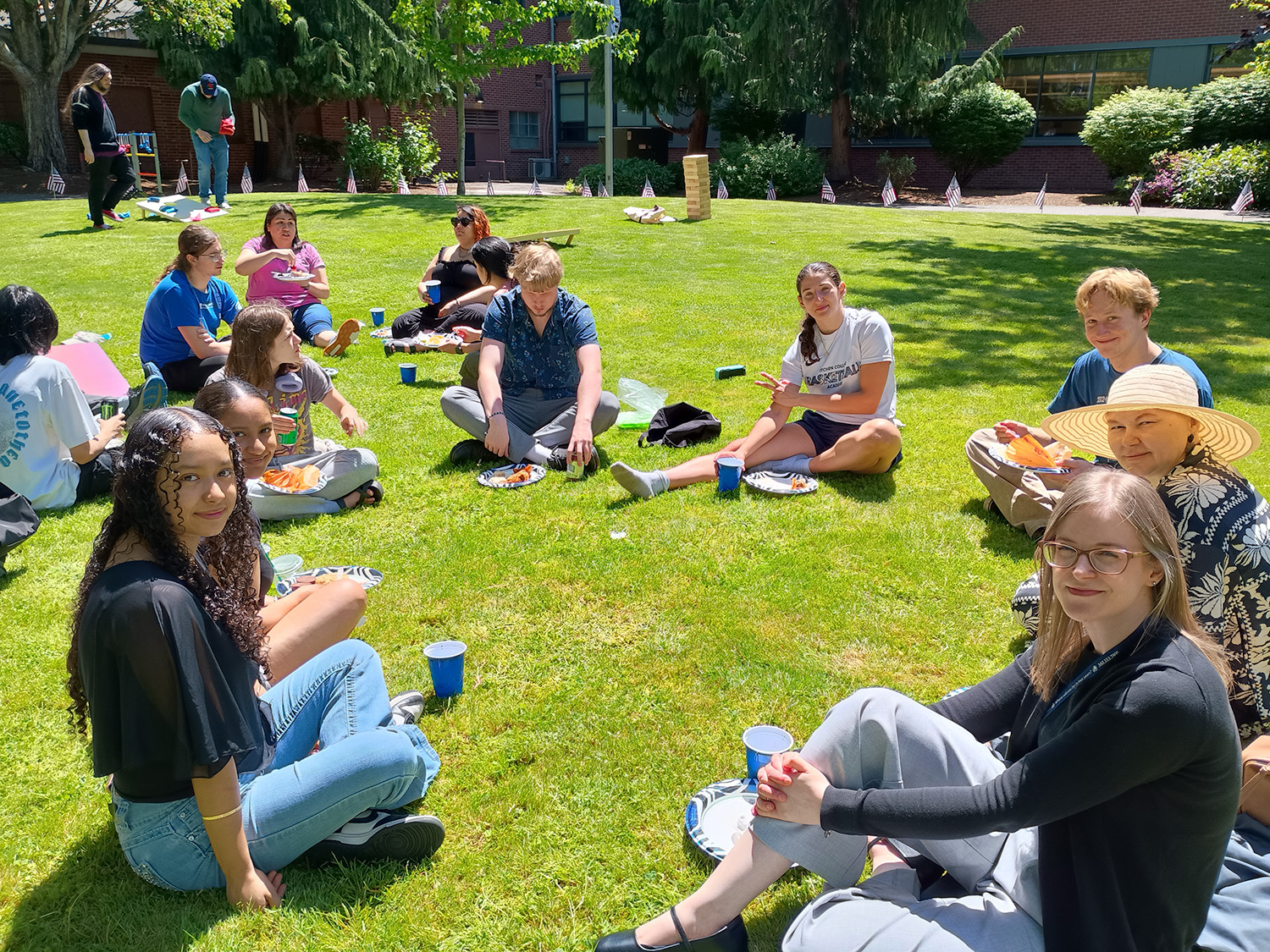 Group Picture 1 People sitting in the grass chatting while eating food