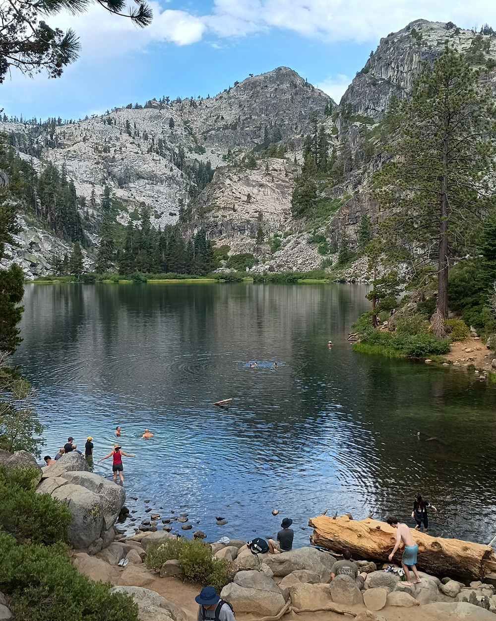Eagle lake withseveral people swimming in it and a hill in the background