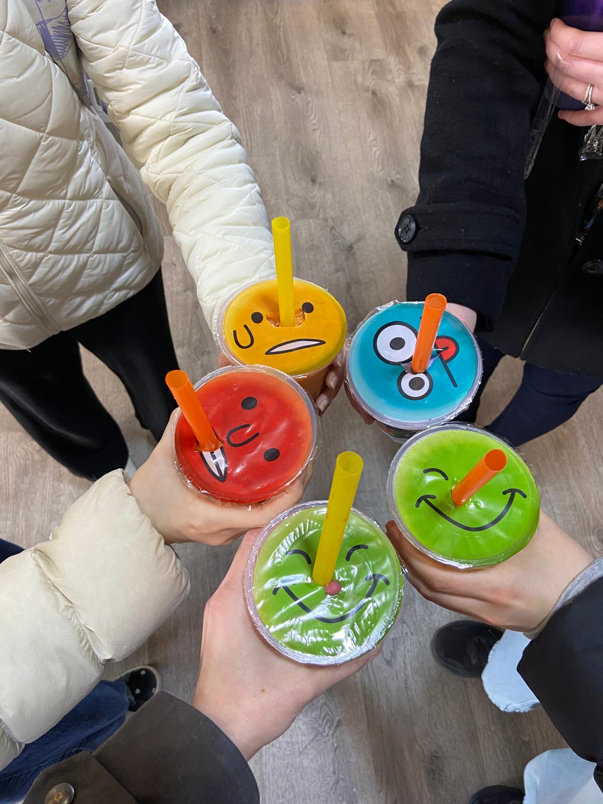 5 students toasting their bubble teas together.
