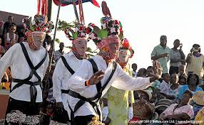 Garifuna Christmas dance competition with men in masks and costumes dancing to live drumming