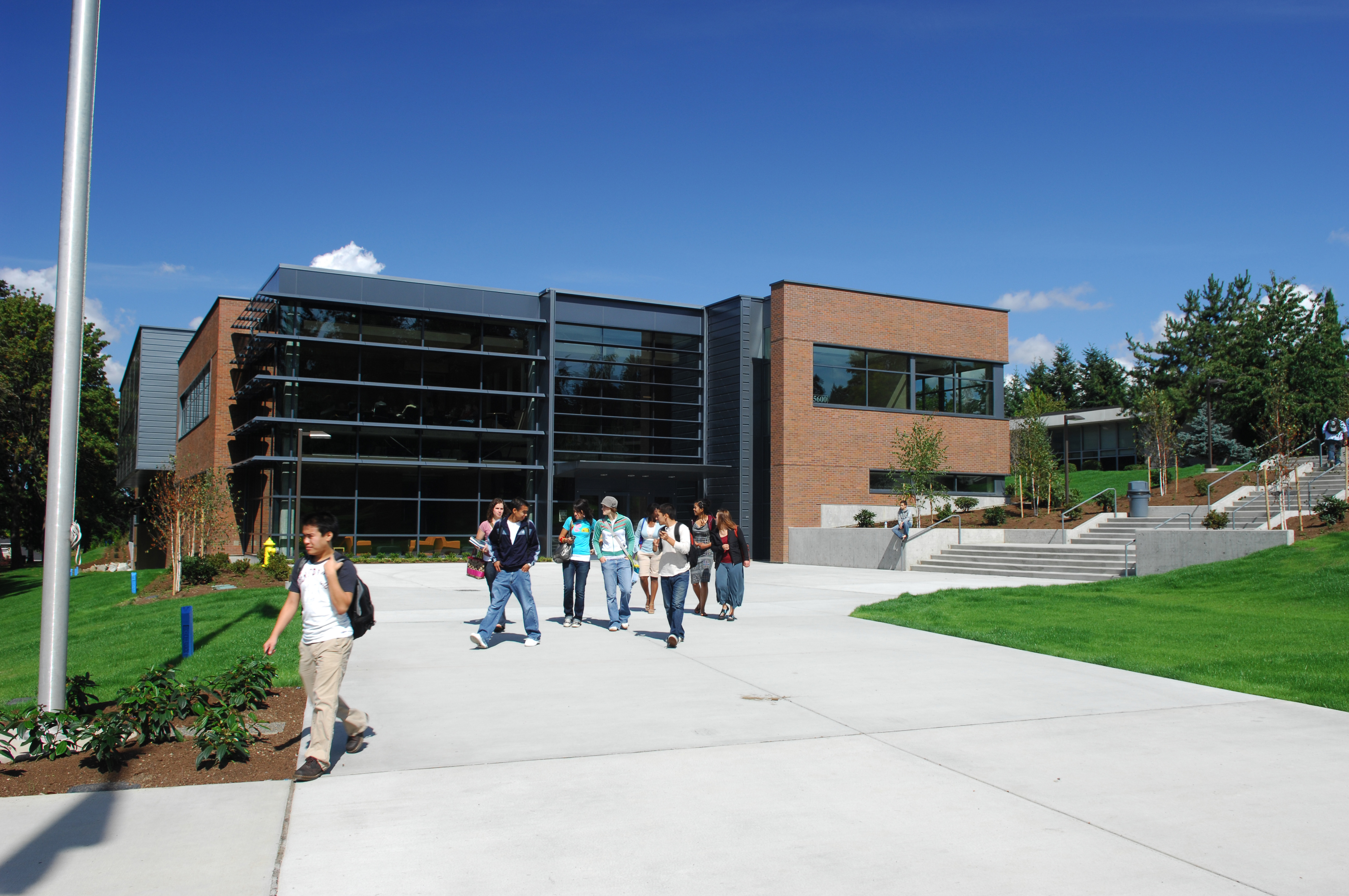 College Students walking in front of university buildings on a sunny day