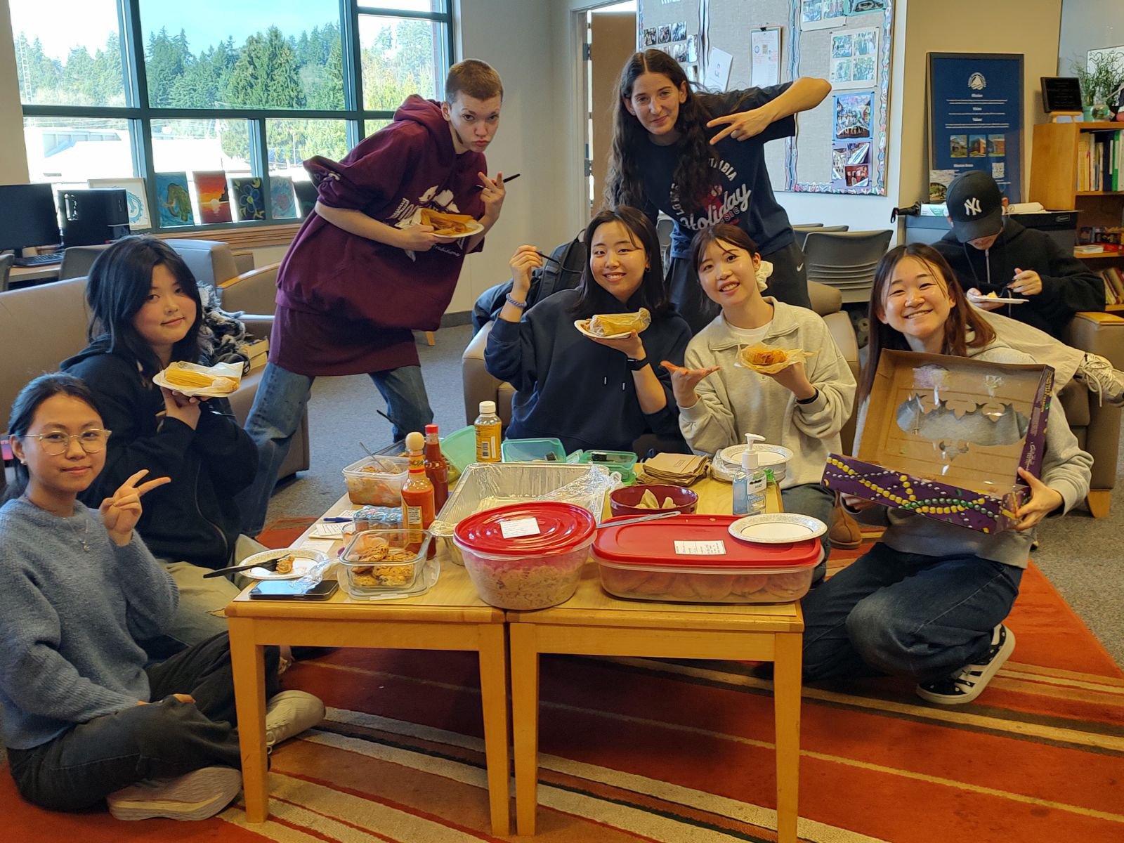 International Club Members of the international club sitting around a small table enjoying food from different cultures