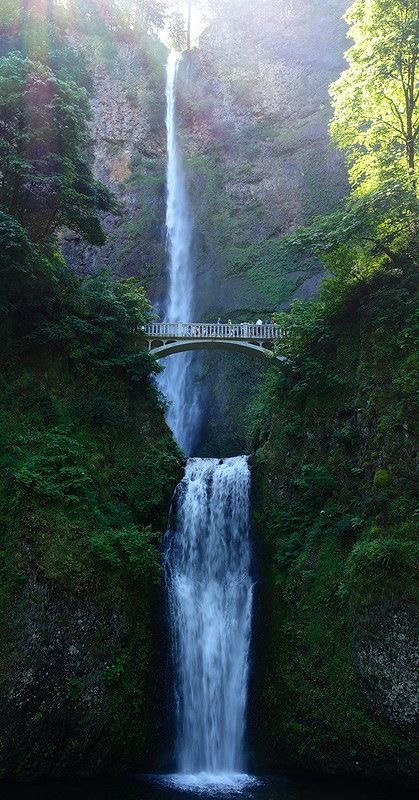 a bridge with a waterfall behind it