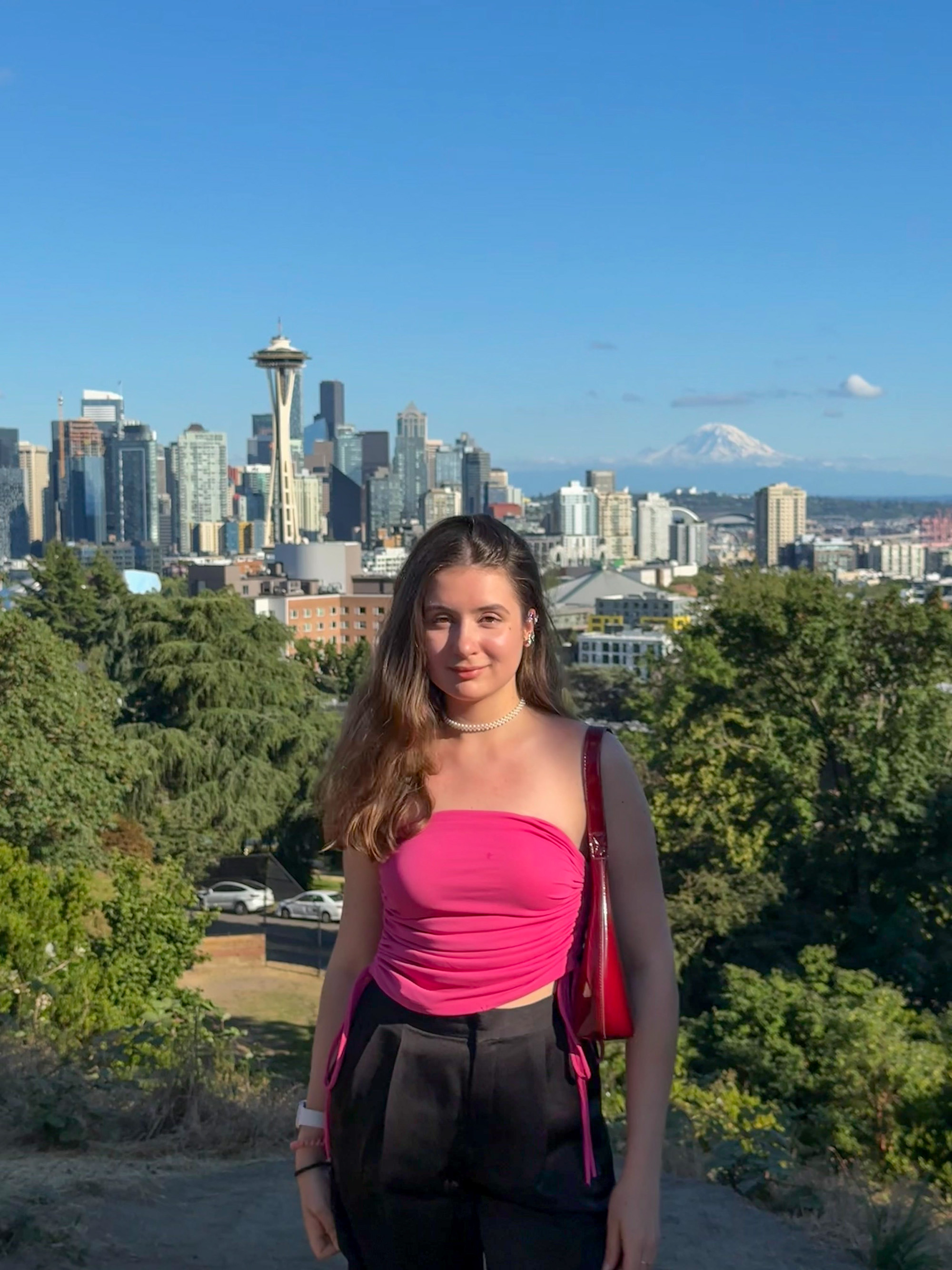 Seattle-Ania with the city Ania standing with her back to the seattle skyline