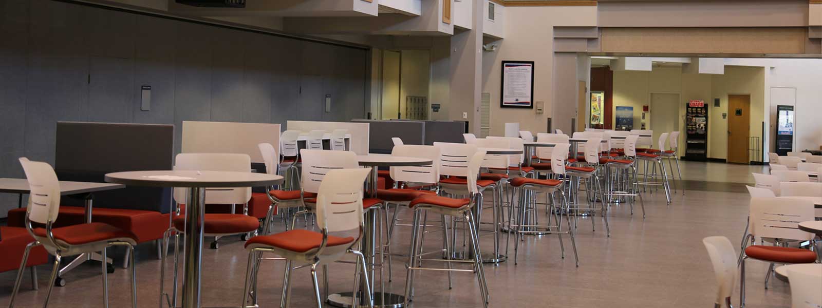 LCC Student Center cafeteria with chairs and tables and no students sitting at them.