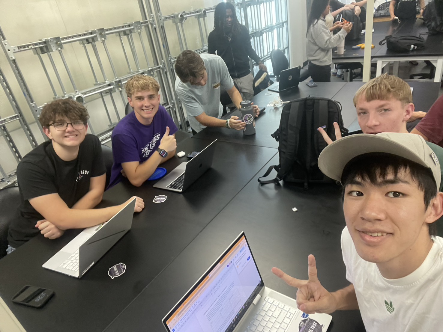 students studying with laptops and supplies in a group at the library