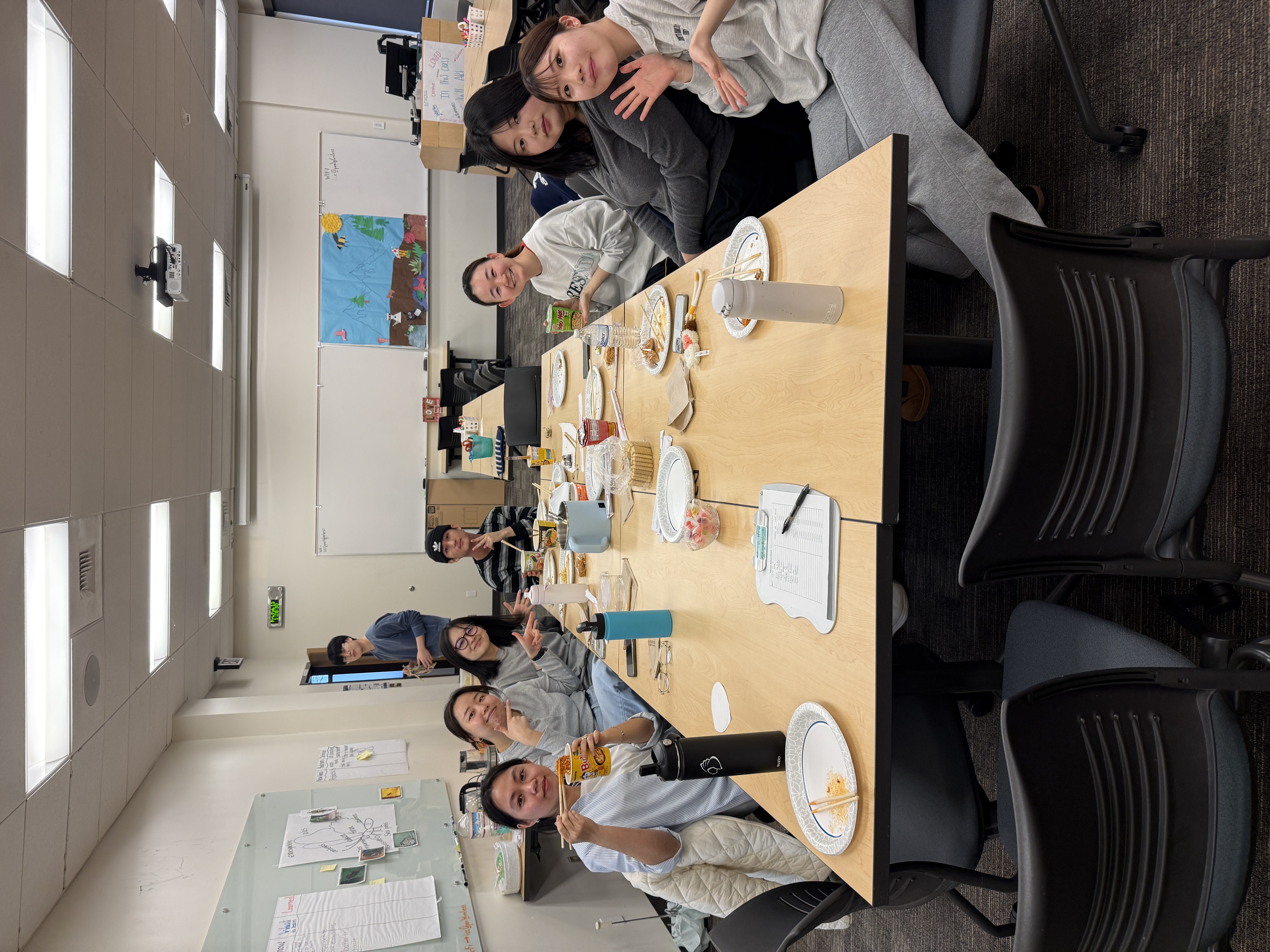 room of international program students socializing, eating ramen, and playing games