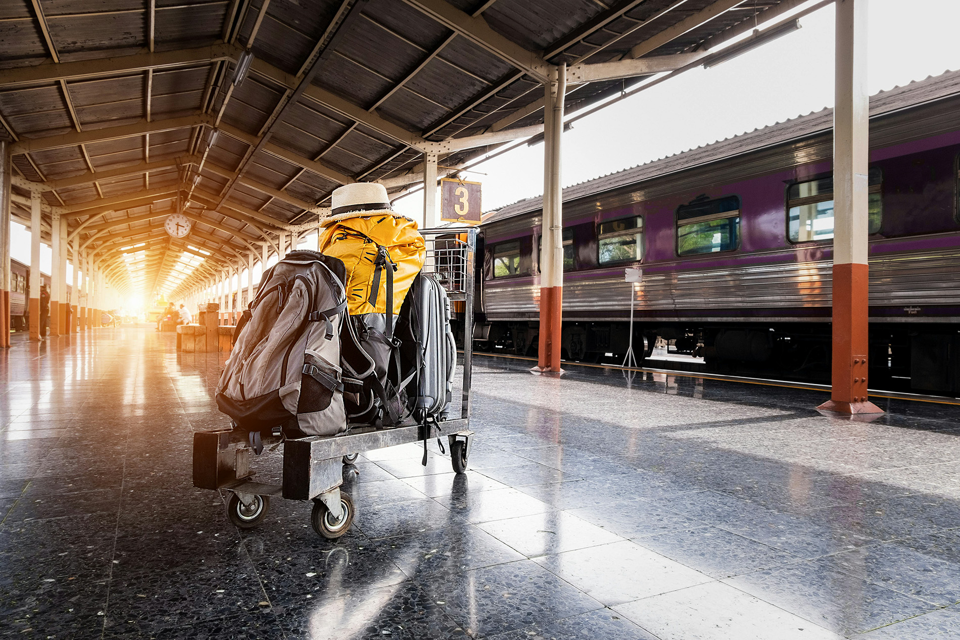 Luggage cart a loaded luggage cart waiting on a sunlit train platform