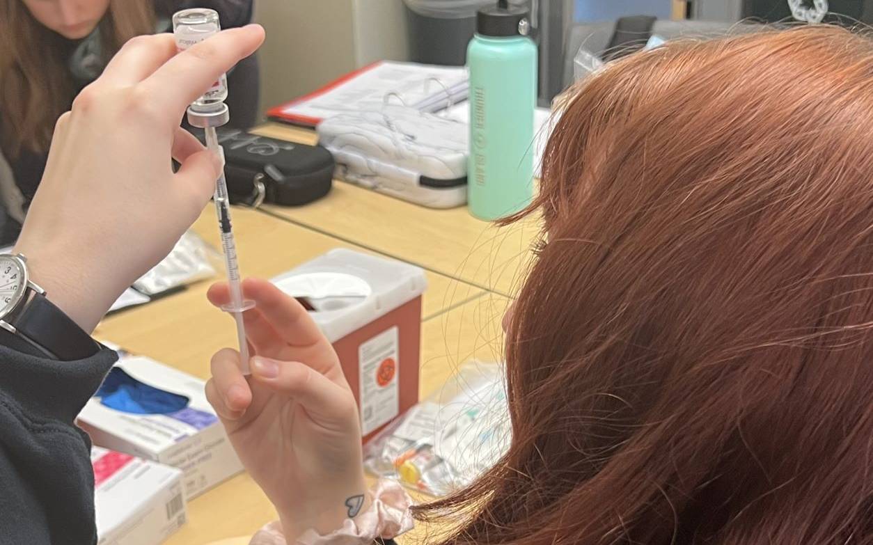 Nursing student measuring from vial