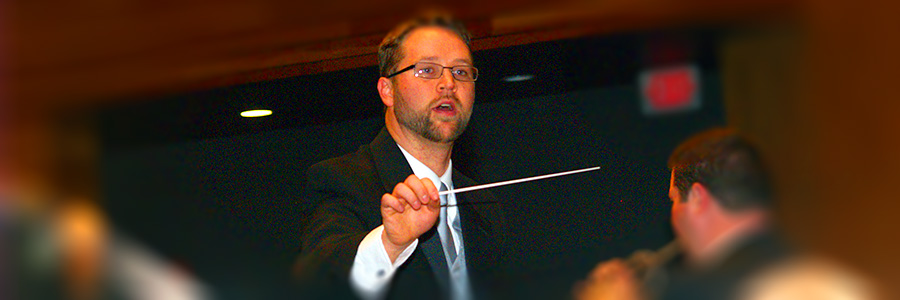 A photo of director Rob Davis conducting during a band concert