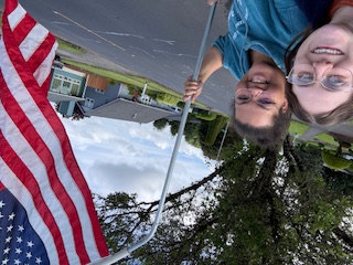 Rotaract members taking a selfie as they install neighborhood American Flags for the Holidays