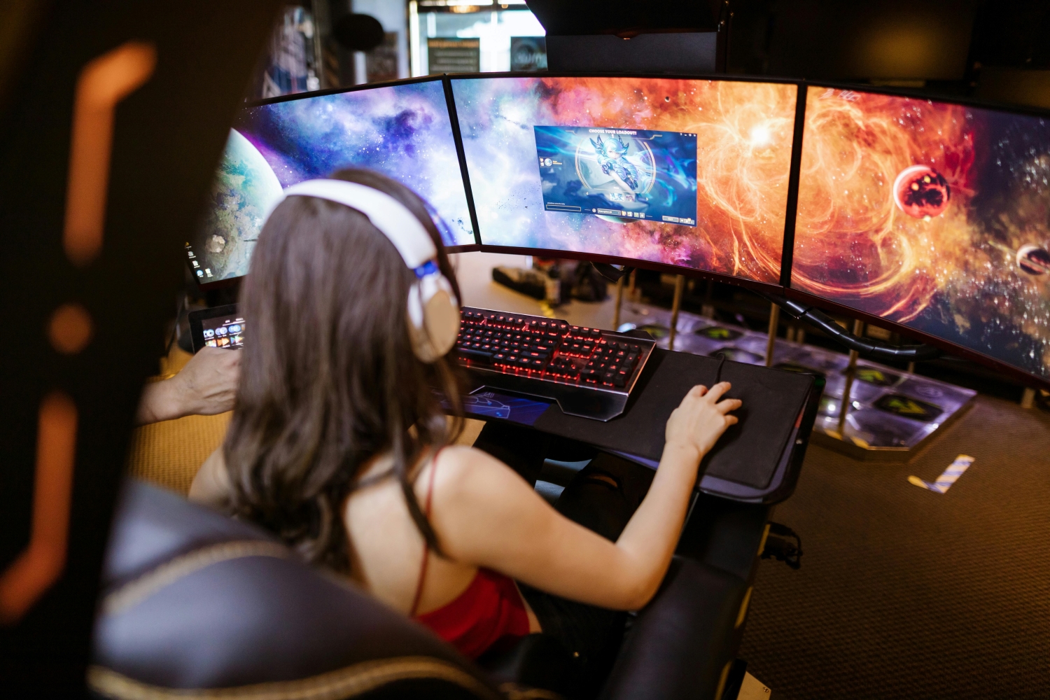 Gamer at desk with three monitors.