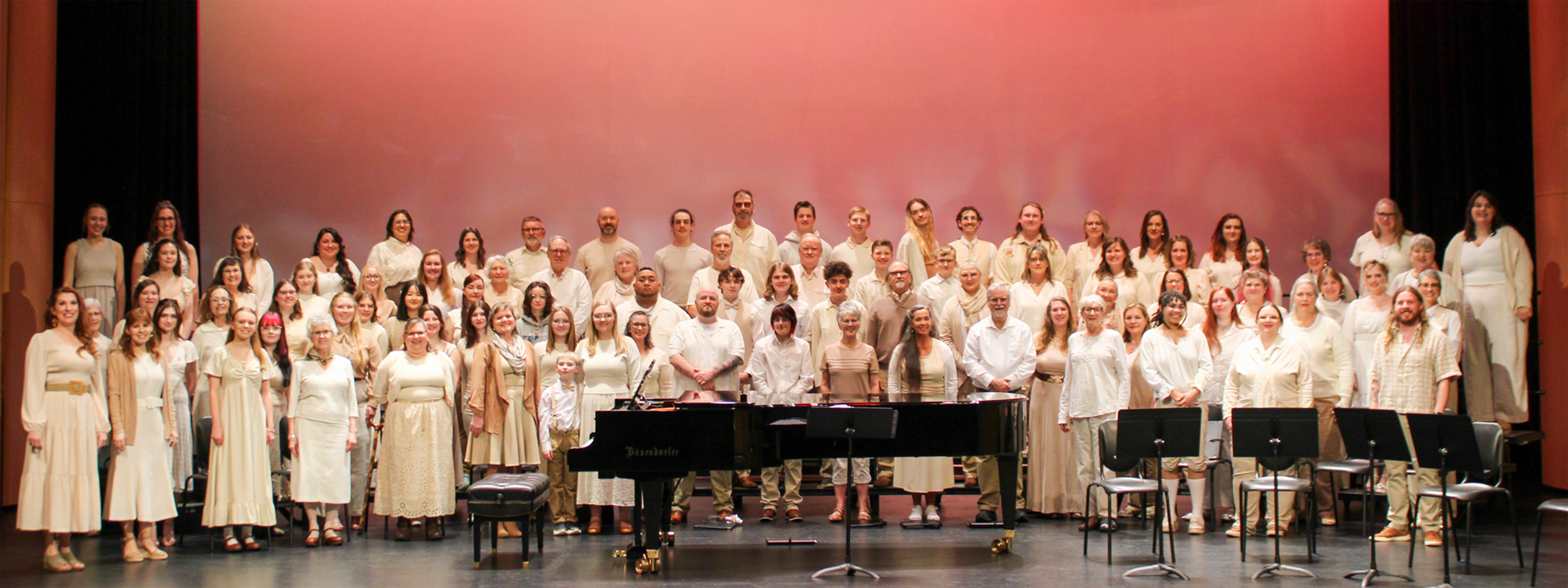 Choir Club standing on choral risers. Wearing all cream colored clothing