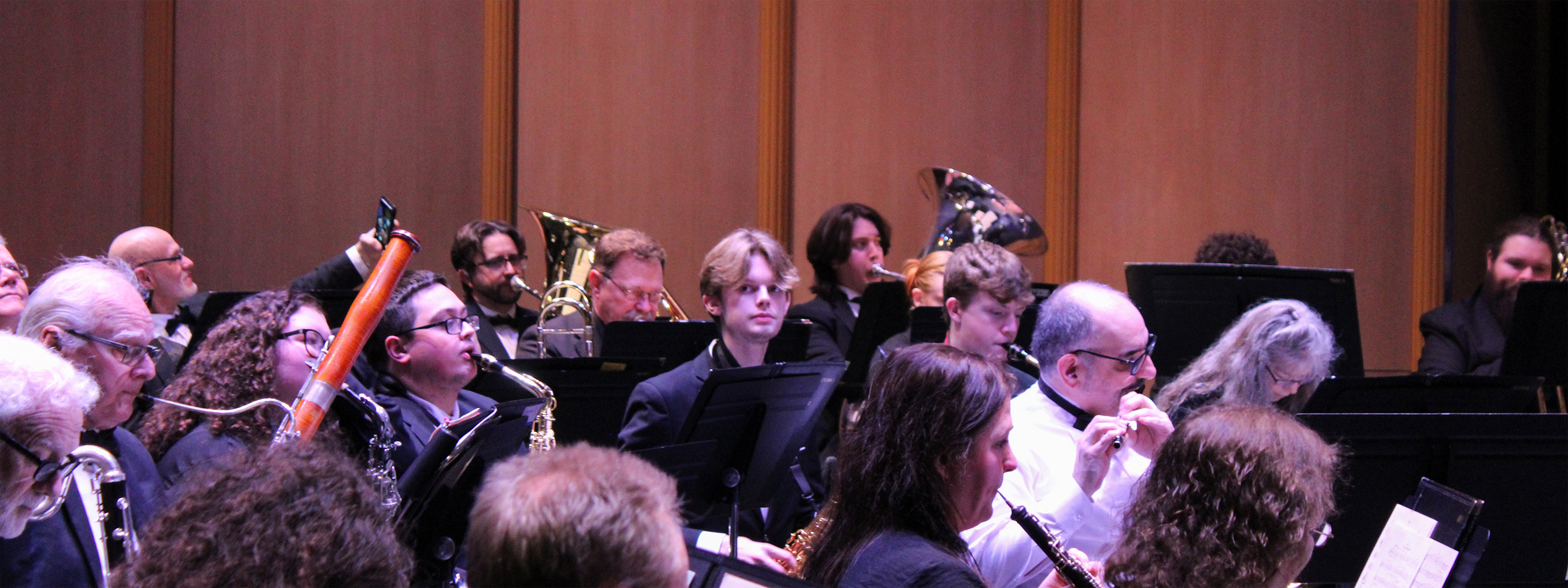 Symphonic band of wind instruments and drum players warming up before a performance