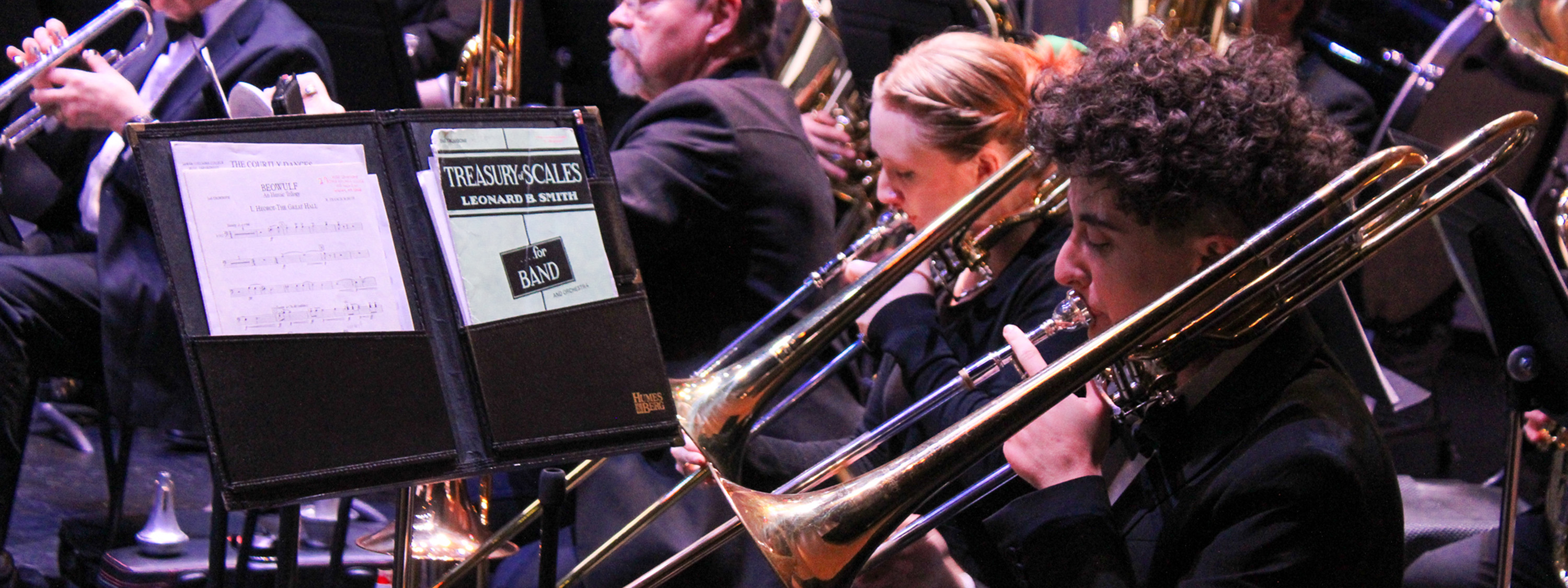 Trombone section of the syphonic band warming up before a performance.