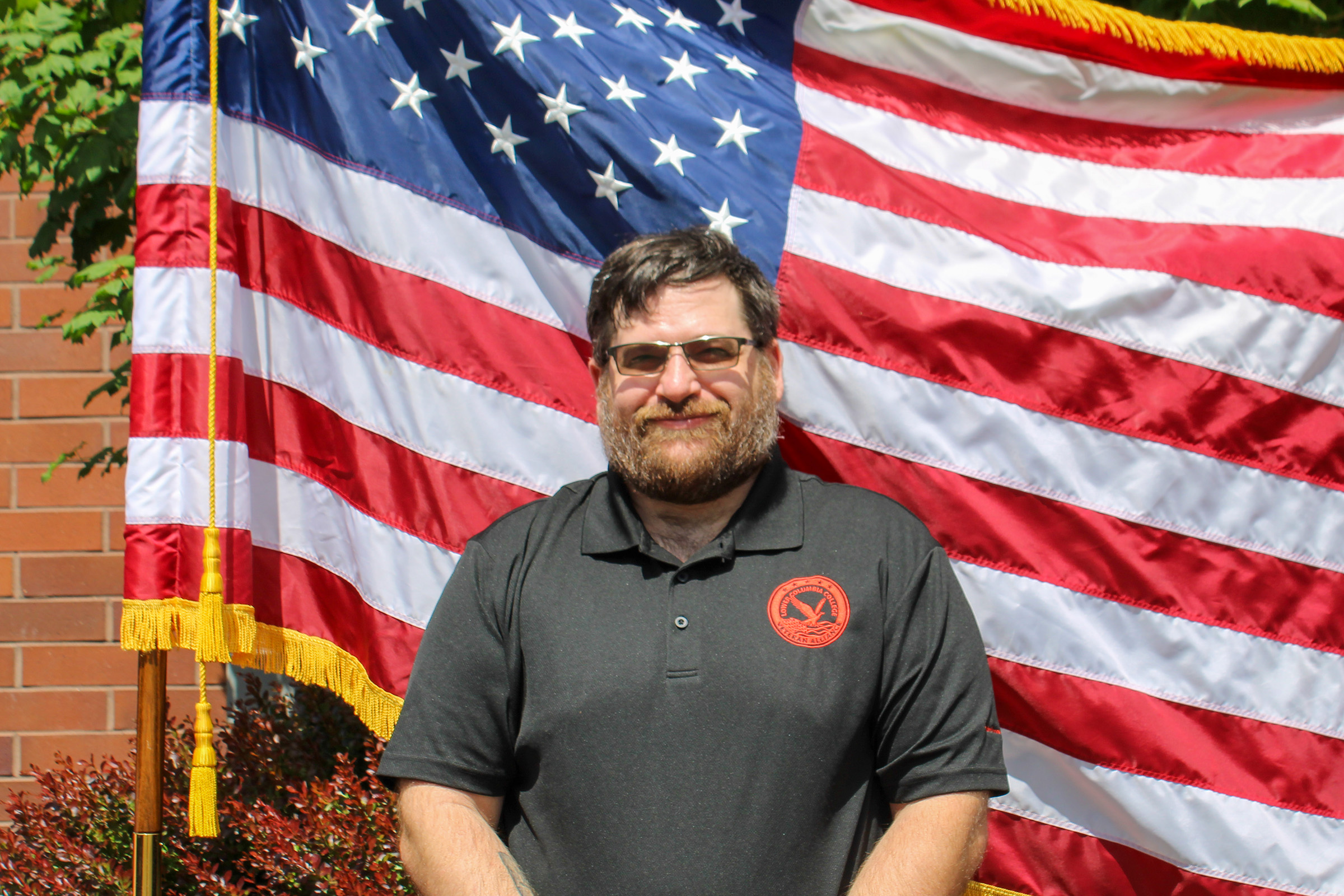 2025-2026 Treasurer of the Veterans Alliance Club 2025-2026 Treasurer of the Veterans Alliance Club standing in front of the American flag